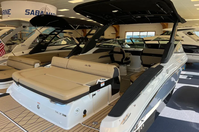 Slide: The Image of 2025 Sea Ray SLX 280 luxury boat with spacious seating and sleek design in showroom. - 14
