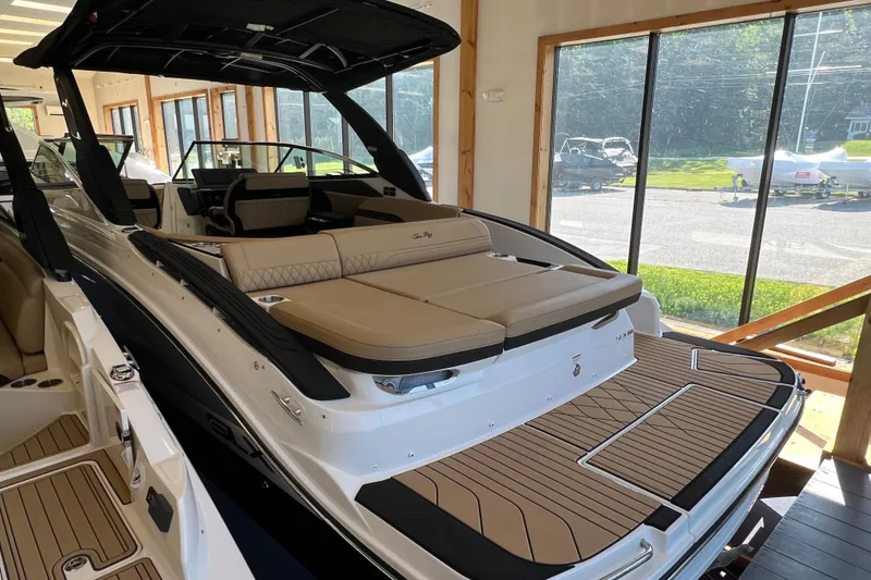 Slide: The Image of 2025 Sea Ray SLX 280 luxury boat with spacious seating and sleek design in showroom. - 15