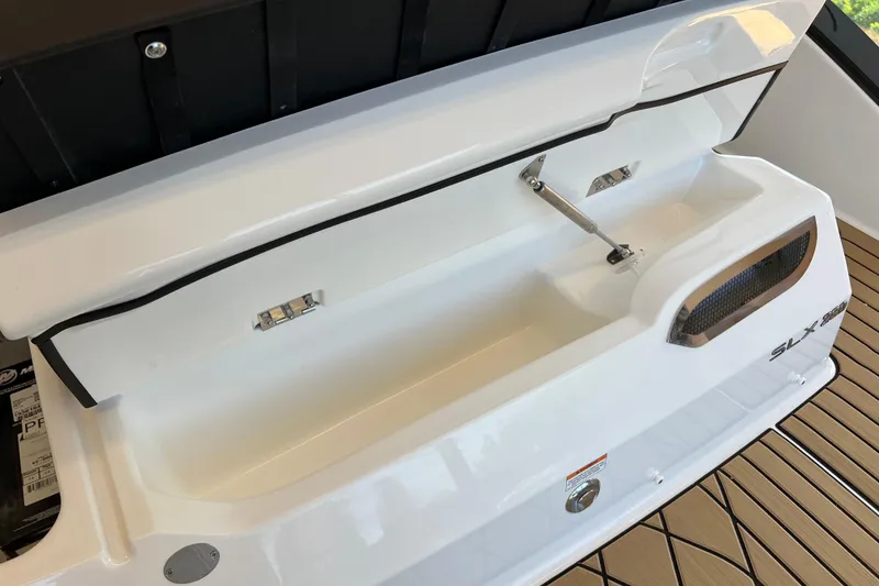 Slide: The Image of 2025 Sea Ray SLX 280 storage compartment with open lid on teak deck. - 17