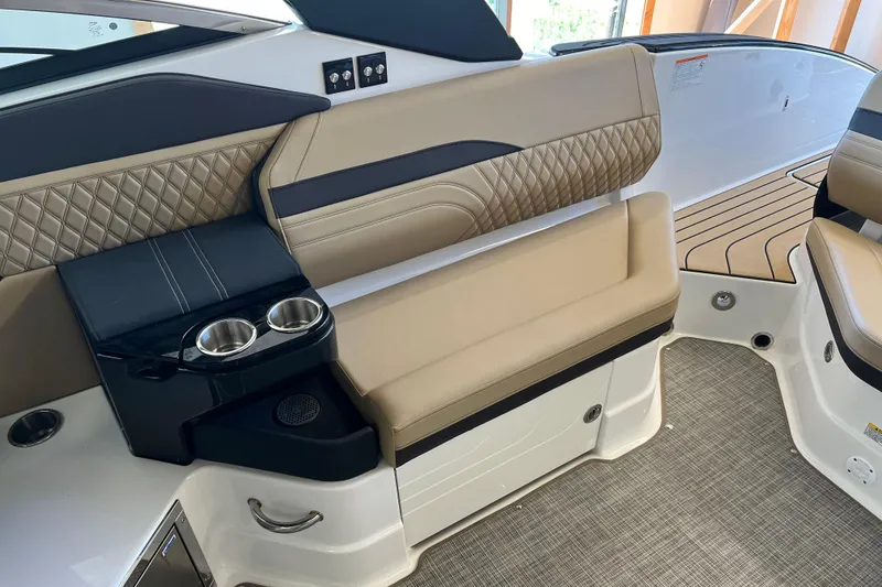 Slide: The Image of 2025 Sea Ray SLX 280 boat interior with beige seating and cup holders. - 21