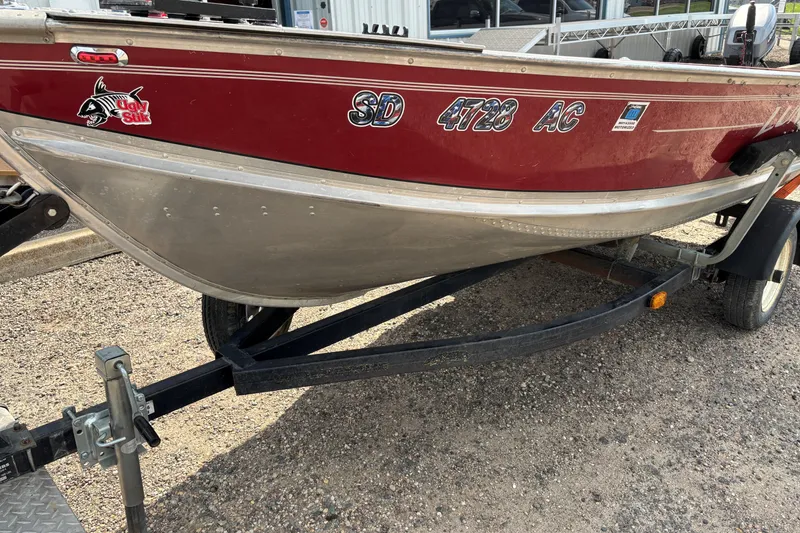 Slide: The Image of 1999 Lund SSV 14 Tiller boat on trailer, red and silver design. - 6