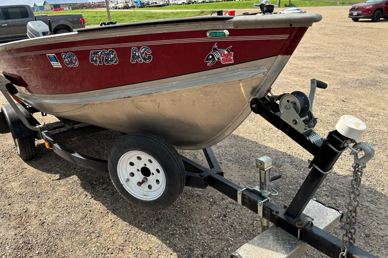 Slide: The Image of 1999 Lund SSV 14 Tiller boat on trailer, parked on gravel lot. - 7