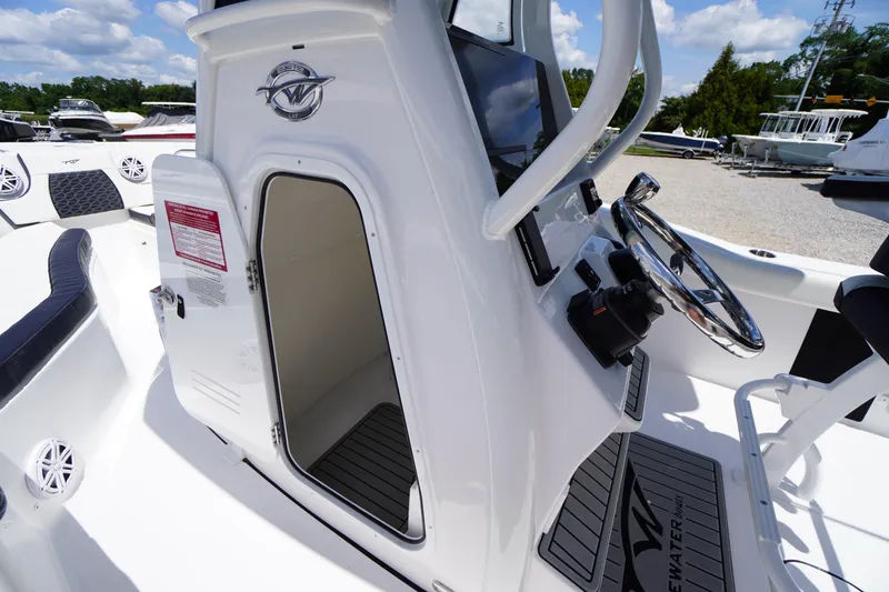 Slide: The Image of 2026 Tidewater 232 LXF boat interior with steering wheel and open cabin door. - 21