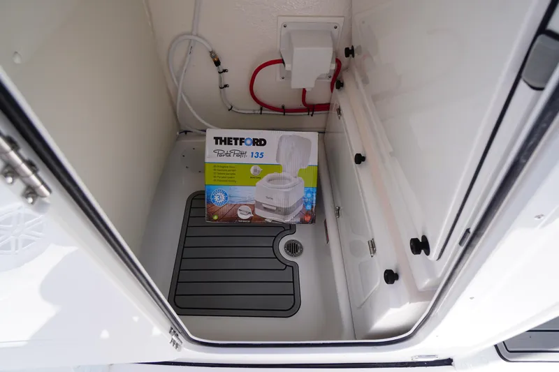 Slide: The Image of Portable toilet in 2026 Tidewater 232 LXF boat storage compartment. - 23