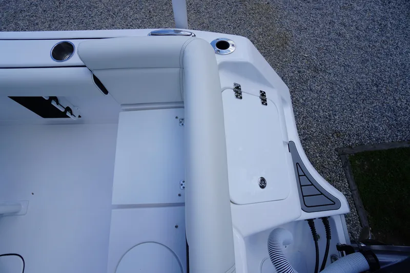 Slide: The Image of 2026 Tidewater 232 LXF boat interior, featuring sleek white seating and storage compartments. - 55