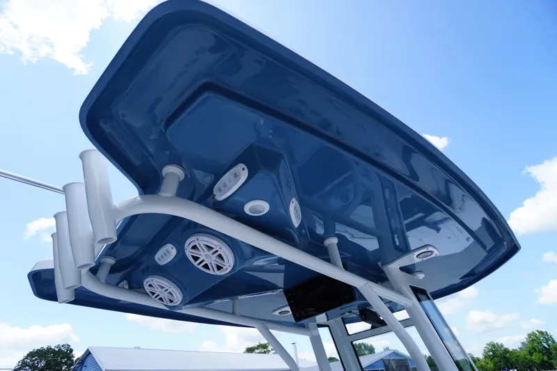 Slide: The Image of 2026 Tidewater 232 LXF boat T-top with speakers and rod holders against blue sky. - 60