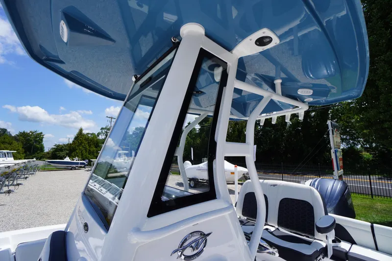 Slide: The Image of 2026 Tidewater 232 LXF boat with blue T-top and sleek design in a sunny outdoor setting. - 65