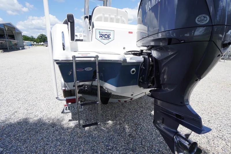 Slide: The Image of 2026 Tidewater 232 LXF boat with Yamaha engine and ladder on gravel surface. - 76