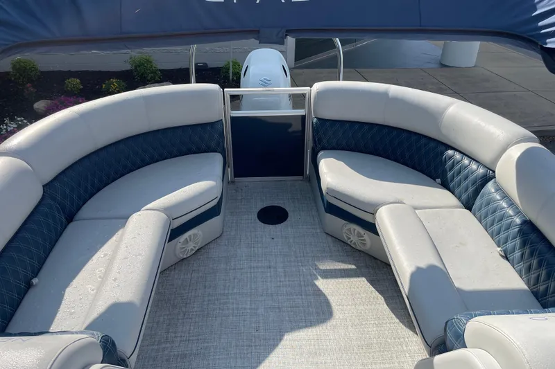 Slide: The Image of 2023 Nepallo 24QL Sport Toon boat interior with blue and white seating, outdoor setting. - 4