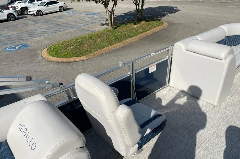 Slide: The Image of 2023 Nepallo 24QL Sport Toon boat interior with white seating in a parking lot. - 6