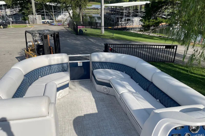 Slide: The Image of 2023 Nepallo 24QL Sport Toon pontoon boat with spacious seating, docked near a marina. - 7
