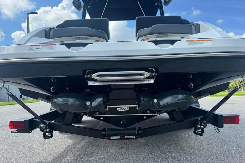 Slide: The Image of Rear view of a 2023 Scarab 255 ID boat on a trailer under a blue sky. - 17
