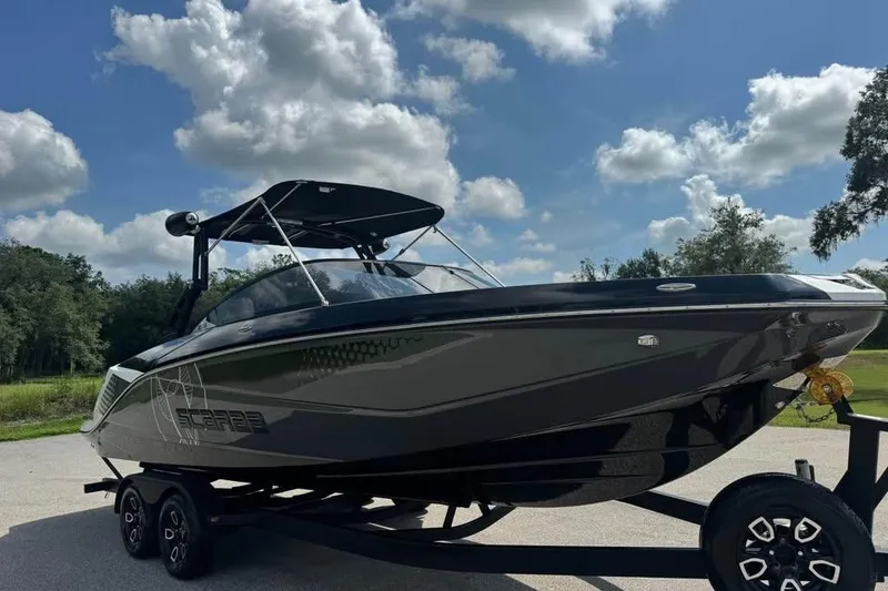 Slide: The Image of 2023 Scarab 255 ID boat on trailer under a blue sky with clouds. - 3