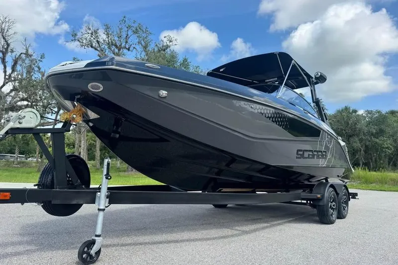 Slide: The Image of 2023 Scarab 255 ID boat on trailer, sleek black design, parked outdoors. - 7