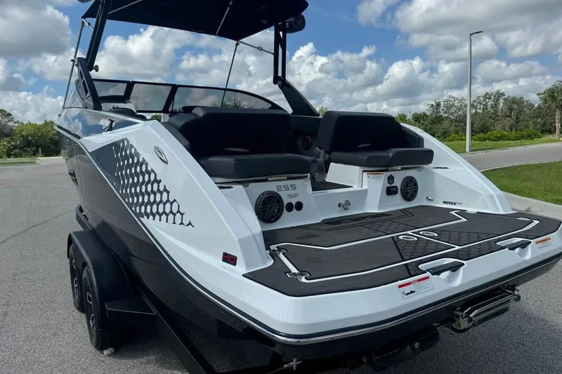Slide: The Image of 2023 Scarab 255 ID boat, rear view, parked on a sunny day. - 9