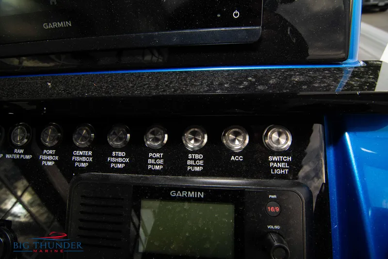 Slide: The Image of Control panel of 2023 Fountain 34 CC boat with Garmin display and various pump switches. - 53