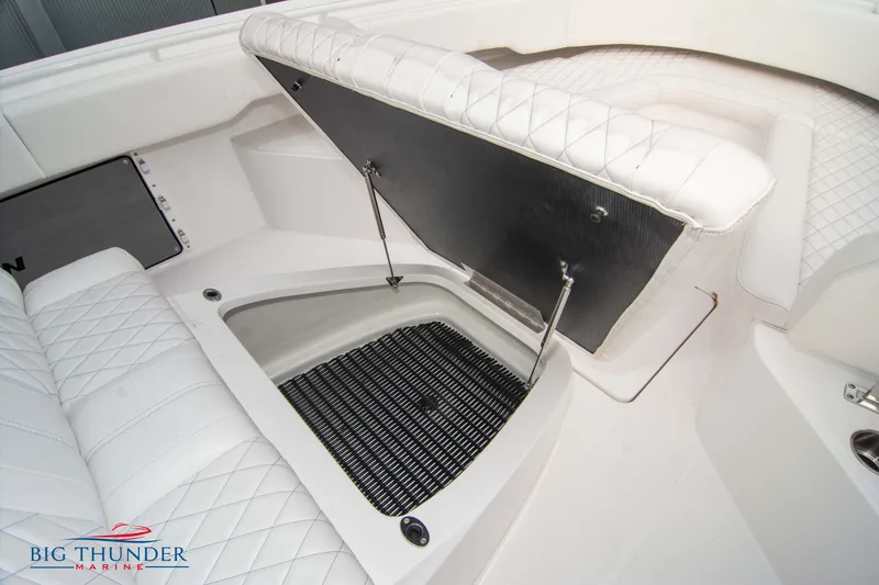Slide: The Image of 2023 Fountain 34 CC boat interior with open storage compartment and white quilted seating. - 58