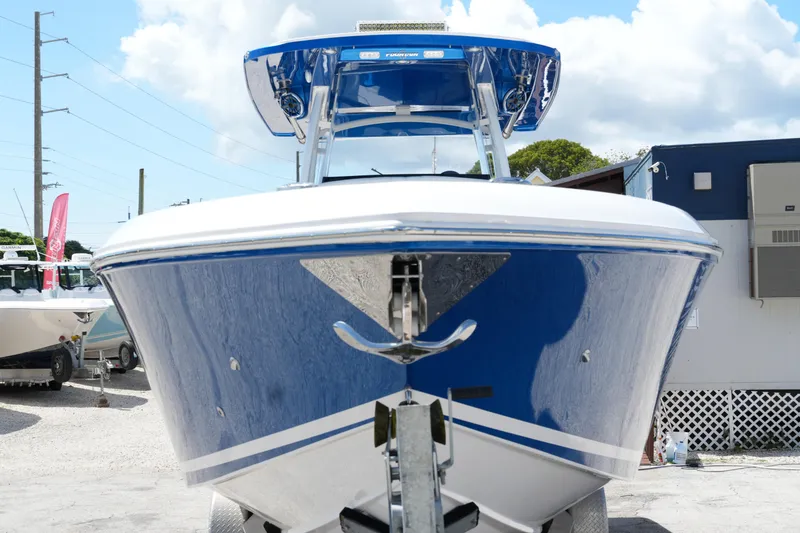 Slide: The Image of 2023 Fountain 34 Center Console boat, blue hull, parked on trailer, sunny day. - 6