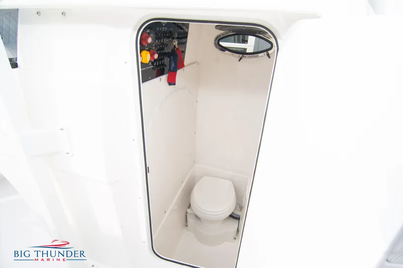 Slide: The Image of 2023 Fountain 34 CC boat interior with compact marine toilet and control panel. - 60