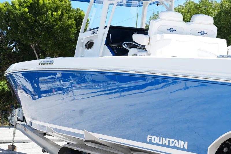 Slide: The Image of 2023 Fountain 34 Center Console boat with sleek blue hull and white seating. - 8