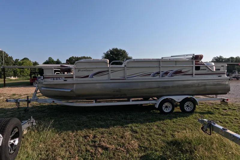 Slide: The Image of 2006 PlayCraft Sunfish 2400 pontoon boat on trailer, parked on grassy area. - 1