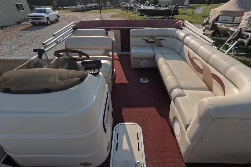 Slide: The Image of 2006 PlayCraft Sunfish 2400 pontoon boat interior with beige seating and red carpet. - 13