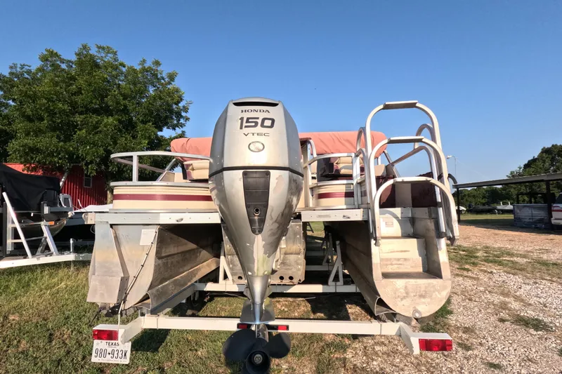 Slide: The Image of 2006 PlayCraft Sunfish 2400 pontoon boat with Honda 150 VTEC engine, parked on trailer. - 15