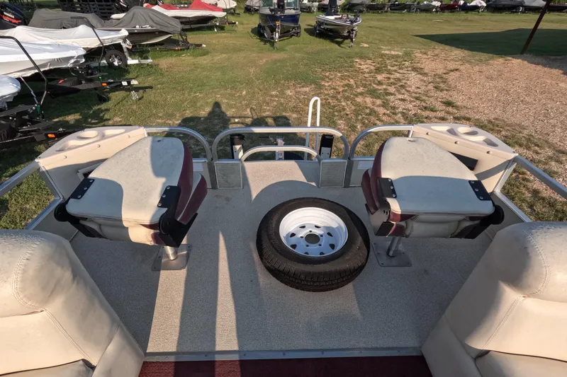 Slide: The Image of 2006 PlayCraft Sunfish 2400 pontoon boat deck with seating and spare tire. - 4