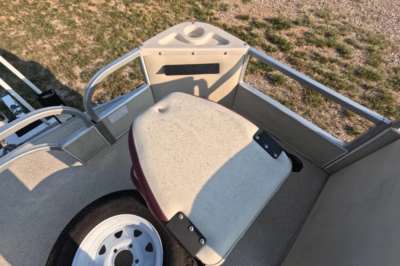 Slide: The Image of 2006 PlayCraft Sunfish 2400 boat interior with seating and railing, grassy background. - 6