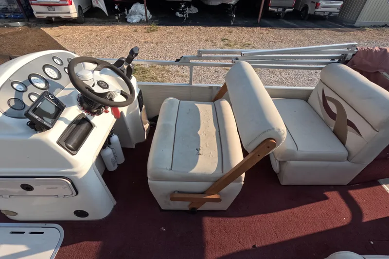 Slide: The Image of 2006 PlayCraft Sunfish 2400 boat interior with steering console and cushioned seating. - 8