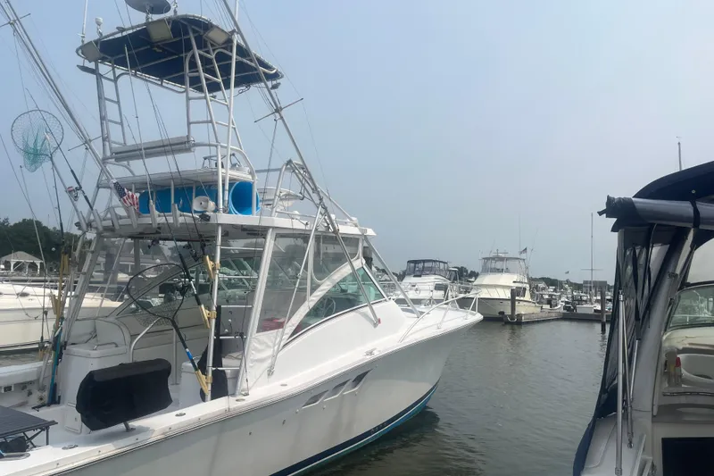 The Image of 1998 Luhrs 36 Open boat docked in a marina, surrounded by other vessels. - 0