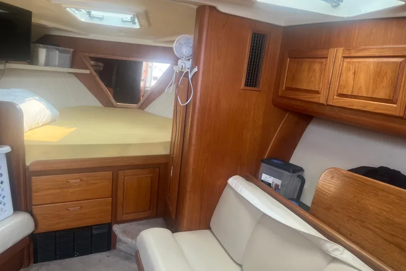 Slide: The Image of 1998 Luhrs 36 Open cabin interior with wood cabinetry and cozy sleeping area. - 11