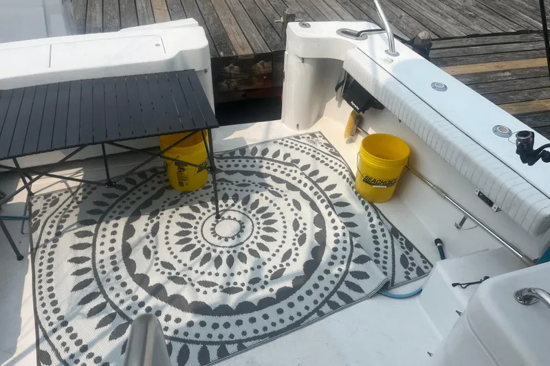 Slide: The Image of 1998 Luhrs 36 Open boat deck with patterned rug, table, and yellow buckets. - 13