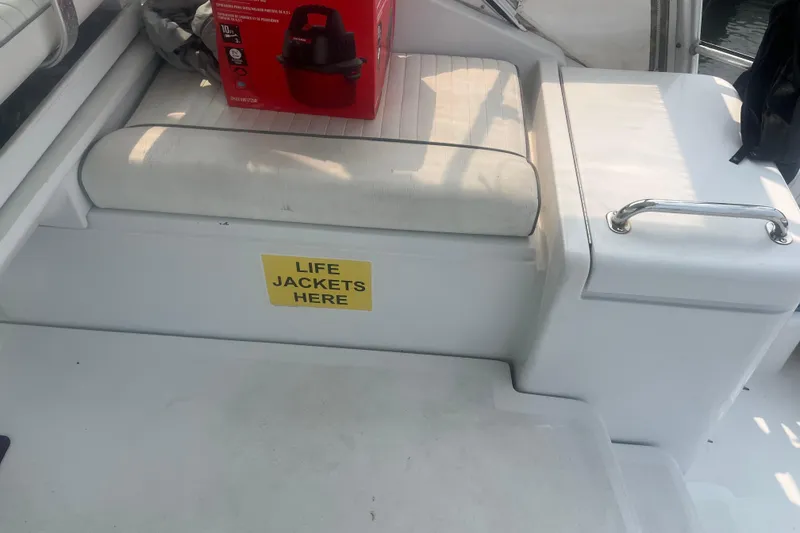 Slide: The Image of 1998 Luhrs 36 Open boat interior with life jacket storage and a red box on the seat. - 15