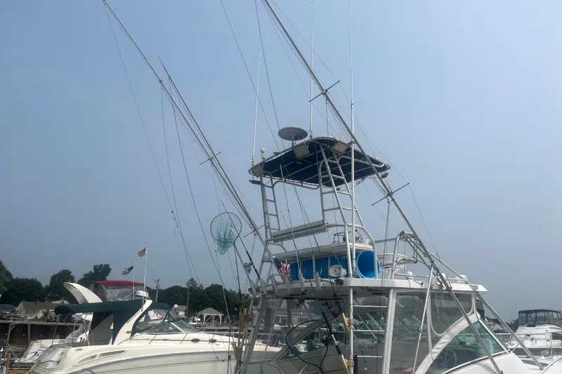 Slide: The Image of 1998 Luhrs 36 Open boat with fishing equipment and radar, docked at a marina. - 2