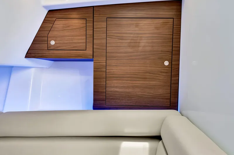 Slide: The Image of Interior of 2023 Boston Whaler 350 Realm with wooden cabinetry and cushioned seating. - 11