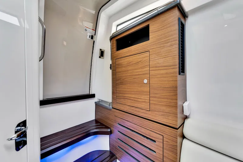 Slide: The Image of 2023 Boston Whaler 350 Realm interior with sleek wood cabinetry and modern design. - 13