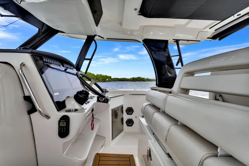 Slide: The Image of Interior view of 2023 Boston Whaler 350 Realm boat, featuring helm and seating area. - 18