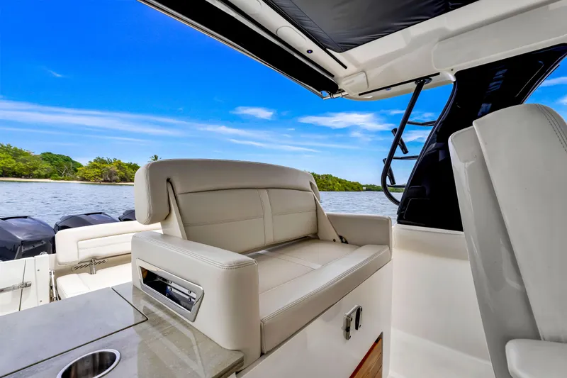 Slide: The Image of 2023 Boston Whaler 350 Realm interior with luxurious seating and scenic water view. - 23