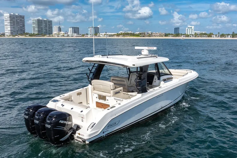 Slide: The Image of 2023 Boston Whaler 350 Realm boat cruising on ocean near city skyline. - 3
