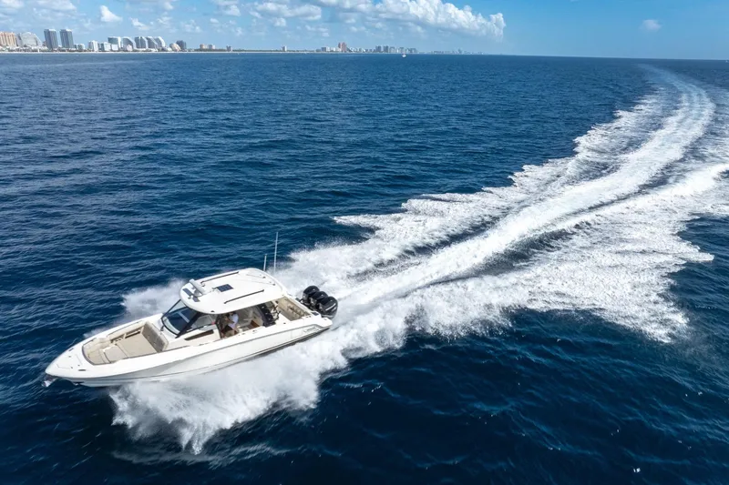 Slide: The Image of 2023 Boston Whaler 350 Realm cruising on open ocean with city skyline in background. - 8