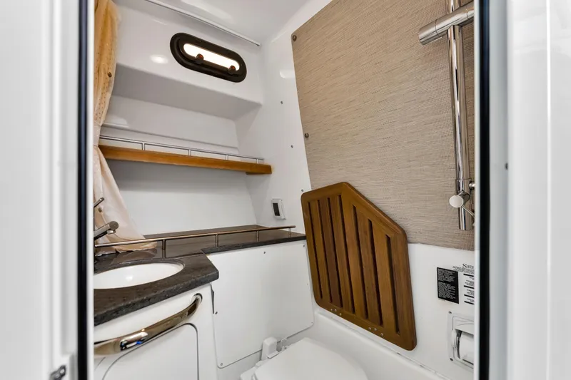 Slide: The Image of 2023 Boston Whaler 350 Realm boat bathroom with modern fixtures and wood accents. - 9