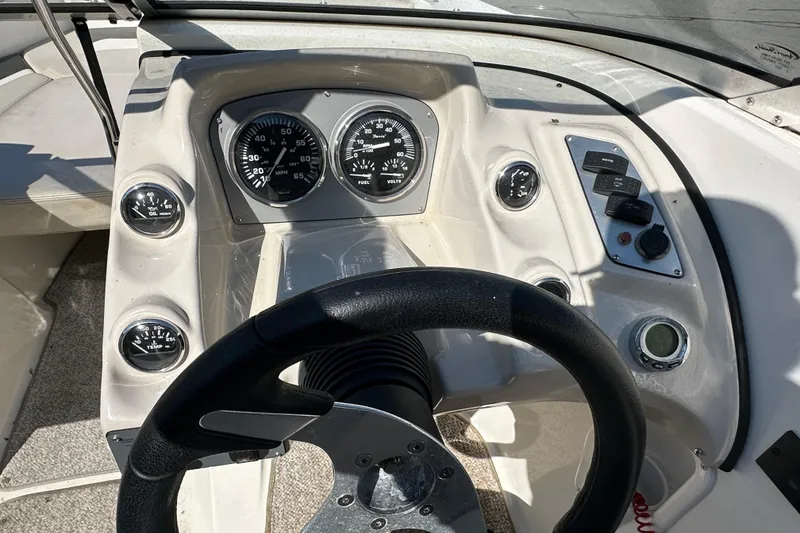 Slide: The Image of 2006 Larson Senza 206 boat dashboard with steering wheel and gauges. - 11