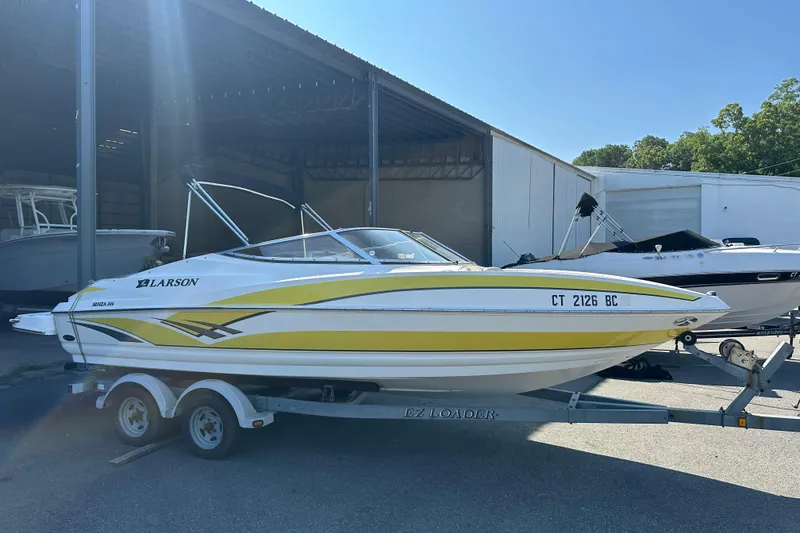 Slide: The Image of 2006 Larson Senza 206 boat on trailer, parked in a storage facility. - 2