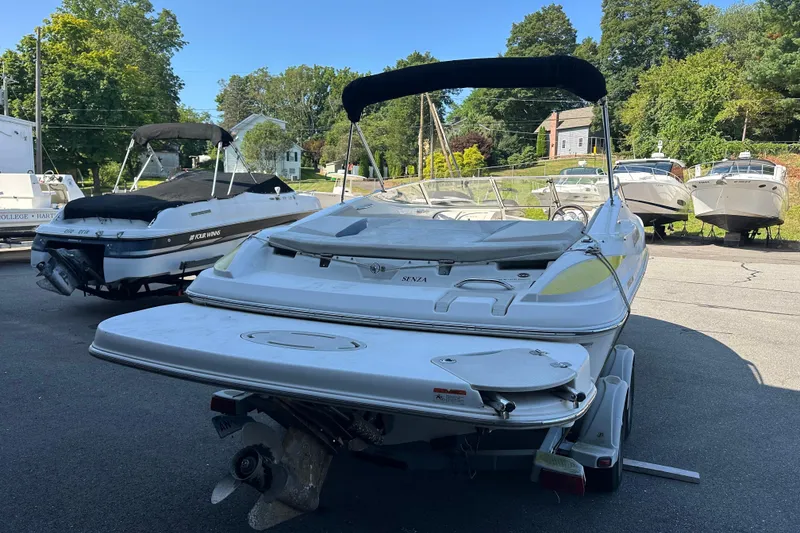 Slide: The Image of 2006 Larson Senza 206 boat parked on a trailer in a marina. - 3