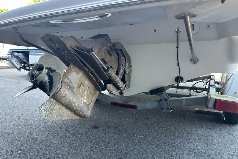 Slide: The Image of 2006 Larson Senza 206 boat with visible propeller and trailer, parked on asphalt. - 4