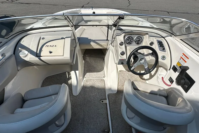 Slide: The Image of Interior of a 2006 Larson Senza 206 boat, featuring steering wheel and dashboard controls. - 8