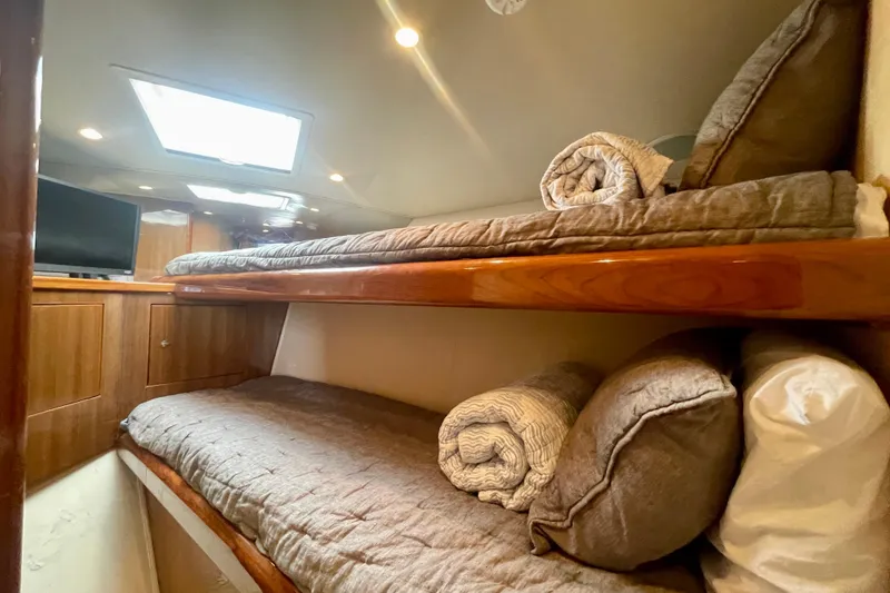 Slide: The Image of 2005 Viking 48 Convertible yacht interior with cozy bunk beds and soft lighting. - 11
