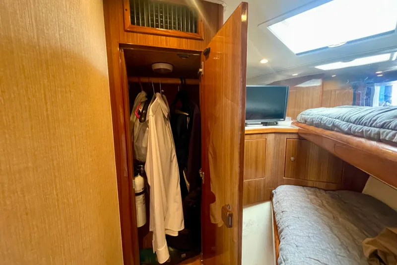 Slide: The Image of 2005 Viking 48 Convertible cabin with open closet, TV, and bunk beds. - 12