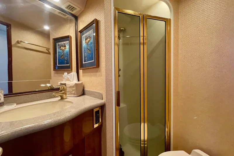 Slide: The Image of Luxurious bathroom in 2005 Viking 48 Convertible yacht with gold accents and framed artwork. - 19